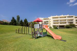 a playground with a slide and an umbrella at Marachique Villa - Torralvor in Alvor