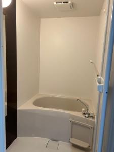 a white bath tub in a bathroom with a sink at 金の森民泊 in Osaka +13 photos