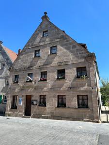 ツィルンドルフにあるAltstadtpension Zirndorfの通りに窓のある古い石造りの建物
