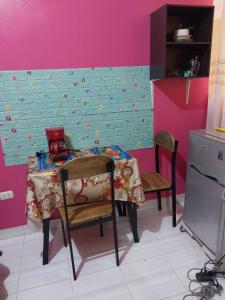 a table and chairs in a kitchen with a pink wall at D203 in Moyobamba