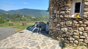 a couple of benches sitting next to a stone wall at Gite en Cevennes 4 personnes in Ponteils-et-Brésis