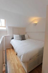 a large white bed in a bedroom with a window at The Coach House, Clifton and Parking - Hopewell in Bristol