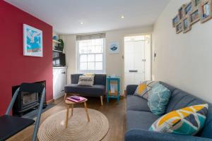 a living room with a blue couch and a fireplace at Super central cosy & cute North Laine cottage in Brighton & Hove