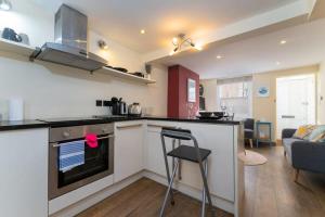 a kitchen and living room with a counter and a stove at Super central cosy & cute North Laine cottage in Brighton & Hove