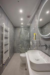 a bathroom with a sink and a toilet and a mirror at Olia seaside residence 120m from the beach in Pefkochori