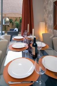 une table à manger avec des assiettes blanches et des verres à vin dans l'établissement Deluxe Townhouse Next to Cabot Circus, à Bristol