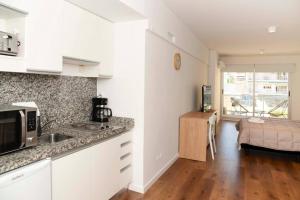 eine Küche mit weißen Schränken und einer Arbeitsplatte in der Unterkunft Belgrano amplio luminoso, cochera, WiFi, cerca River y Subte, 309 in Buenos Aires