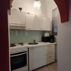 a kitchen with white cabinets and a stove top oven at Cozy City Apartment - sleeps 2 in Rhodes Town
