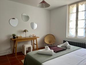 a bedroom with a bed and a table and mirrors at Château de la Sybille, vue imprenable sur le Canigou et les Orgues d'Ille sur Têt in Ille-sur-Têt