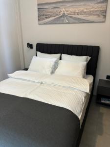 a large bed with white sheets and pillows at City room Zagreb in Zagreb