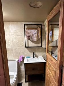 Un baño con lavabo, inodoro y espejo. en Bayt Al Habib, 