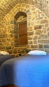 Una cama en un edificio de piedra con ventana. en Bayt Al Habib, 