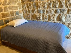 una cama en una habitación con una pared de piedra en Bayt Al Habib,  11 fotos más