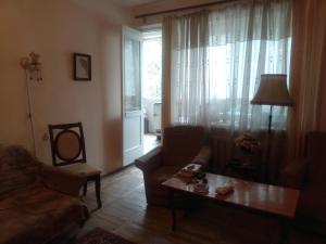 a living room with a couch and a table at Комната в ретро стиле в трехкомнатной квартире с отдельным входом in Yerevan
