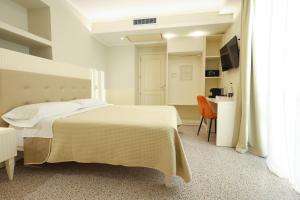 a white bedroom with a bed and a desk at Nazzarì B&B Tropea in Tropea