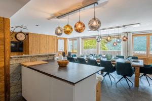a kitchen and dining room with a long table and chairs at Le refuge - pass navette offert in Valloire