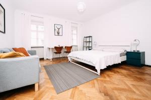 a white bedroom with a bed and a couch at Vienna Premium Naschmarkt in Vienna