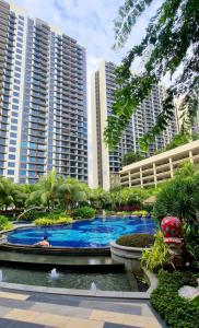 a large swimming pool in front of a building with tall buildings at Central Park Cozy Garden View Studio for 3 pax in Johor Bahru