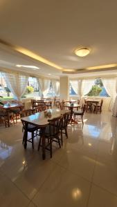 a restaurant with wooden tables and chairs and windows at Pousada Serra Valle in Gramado
