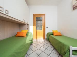 2 Betten mit grünen und orangefarbenen Kissen in einem Zimmer in der Unterkunft Giardino di Nonno Lucio - Surrounded by Lemon Tree in Piano di Sorrento