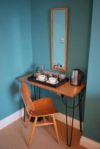 a bathroom with a vanity with a mirror and a chair at The Alma Taverns Boutique Suites - Room 5 - Hopewell in Bristol +5 photos