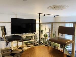 een woonkamer met een flatscreen-tv en twee stoelen bij Modern and Bright Three Bed Apartment in Bristol