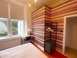 een slaapkamer met een bed en een muur bij Modern and Bright Three Bed Apartment in Bristol