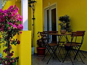 a patio with a table and chairs and flowers at Lemon House Borsh in Himare