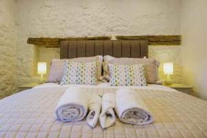 a bedroom with a bed with towels and pillows at The Cottage- Hopewell in Bristol