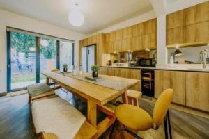 The unicorn's house sleeps 10 people في بريستول: مطبخ كبير بطاولة خشبية وكراسي صفراء +34 صورة