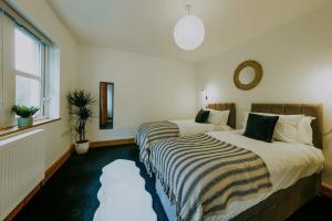 The unicorn's house sleeps 10 people في بريستول: غرفة فندق بها سريران ونافذة