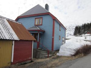 a blue house with a red roof next to a building at The blue house, Røldal in Røldal