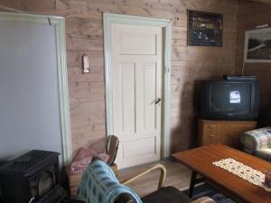 a living room with a door and a tv at The blue house, Røldal in Røldal