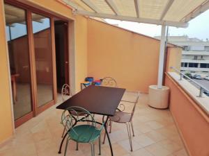 a balcony with a black table and chairs at Casa Levante Gallipoli in Gallipoli +1 photo