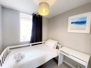 una piccola camera da letto con un letto e una finestra di Deluxe Apartment near Cabot Circus w Parking sleeps 5 a Bristol
