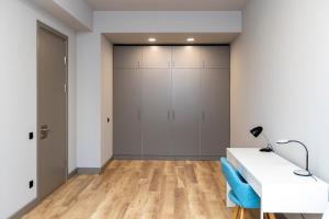 Habitación con escritorio blanco y armario. en Comfortable 1BR Apartment in Central Vake - by Wehost, en Tiflis