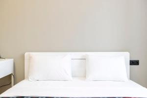 una cama blanca con sábanas y almohadas blancas en Comfortable 1BR Apartment in Central Vake - by Wehost, en Tiflis 16 fotos más
