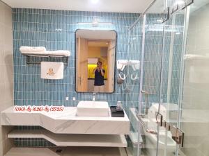 a man taking a picture in a bathroom mirror at IB306 Tự doanh - Flamingo Hải Tiến in Thanh Hóa +33 photos