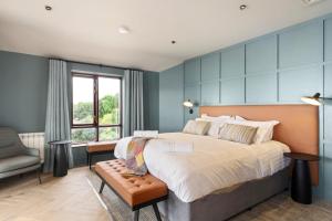 a bedroom with a large bed and a chair at Gold Coast Resort Dungarvan in Dungarvan