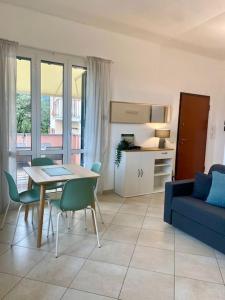 a living room with a table and a blue couch at Appartamento Giardino e Parcheggio in Borgio Verezzi