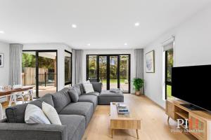 un salon avec un canapé et une télévision dans l'établissement Hot Tub 4Bdr 2Ba Family Home, à Cape Woolamai