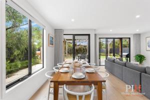 une salle à manger avec une table et un canapé dans l'établissement Hot Tub 4Bdr 2Ba Family Home, à Cape Woolamai