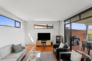 a living room with a couch and a tv at Villa Isola Golf Course Views in Cowes