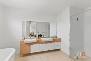 a bathroom with two sinks and a large mirror at Villa Isola Golf Course Views in Cowes +23 photos