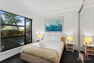 a bedroom with a bed and a large window at Villa Isola Golf Course Views in Cowes