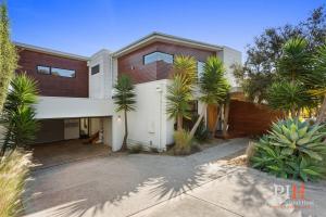 a house with palm trees in front of it at Villa Isola Golf Course Views in Cowes