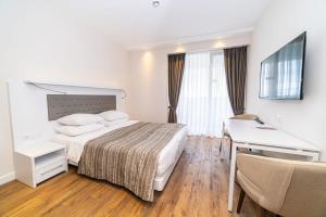 a hotel room with a bed and a desk at Stylish Apt In Alliance Palace in Batumi