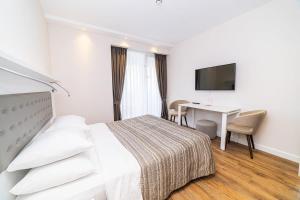 a hotel room with a bed and a desk at Stylish Apt In Alliance Palace in Batumi +18 photos