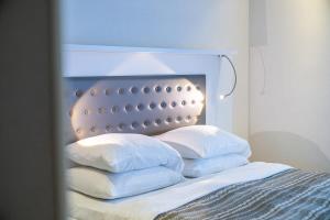 a bedroom with a bed with pillows on it at Stylish Apt In Alliance Palace in Batumi