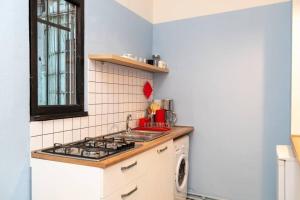 a small kitchen with a stove and a sink at Opera House 2BR Apt with Tbilisi Charm - By Wehost in Tbilisi City